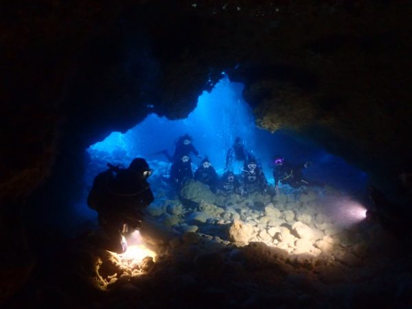 洞窟の中で水中ライトを照らしている様子