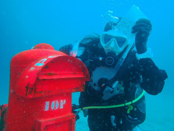 ダイバーが海中ポストに手紙を出している様子