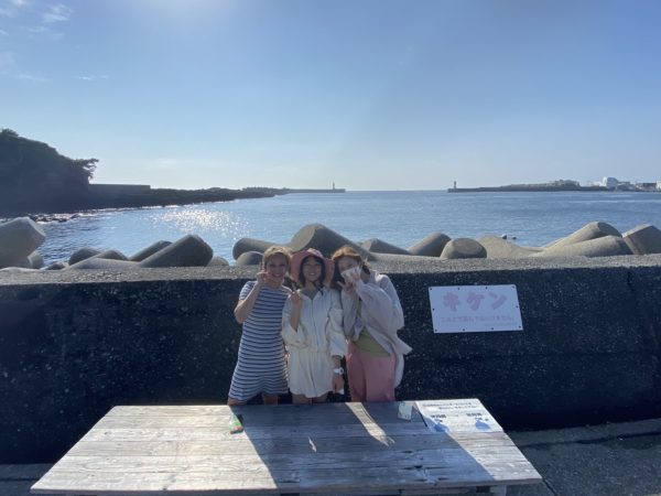 海の前で女性3人で記念写真