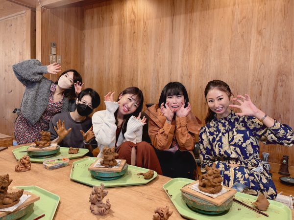 女性5人が完成したシーサーと一緒に記念写真