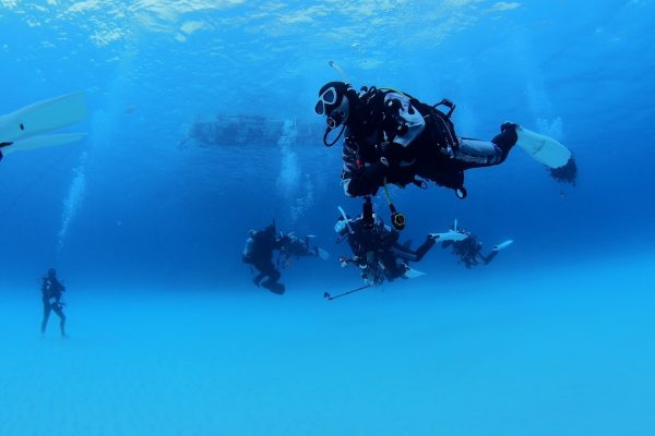 海の中を中性浮力を取って泳ぐ複数のダイバーたち