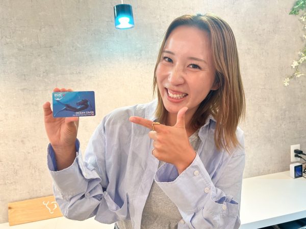 ダイビングのライセンスカードを持つ女性