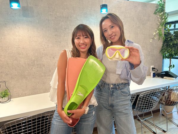 ダイビング器材を抱える女性