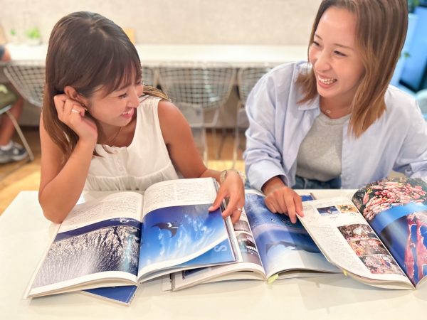 ダイビング雑誌を見て話す女性2人