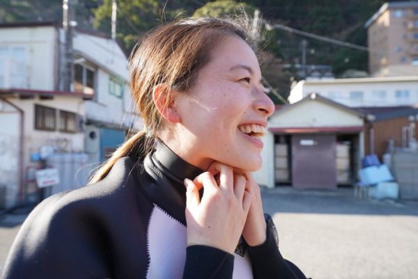 女性がドライスーツの首を調整している様子