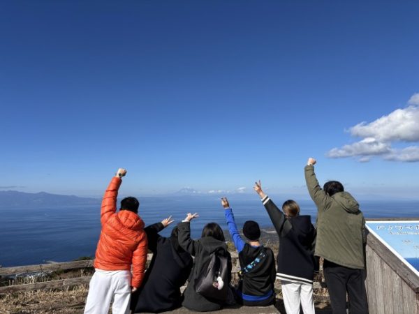 海辺でポーズをとる男女の後ろ姿