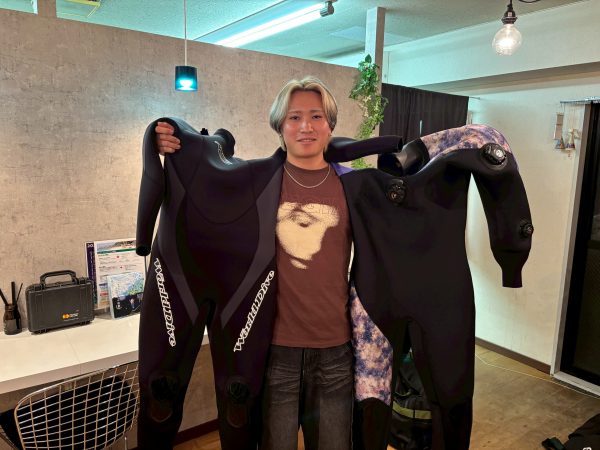 ダイビングスーツを持った男性