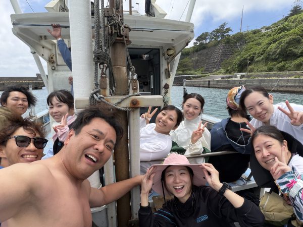 船の上で複数の男女が集合写真