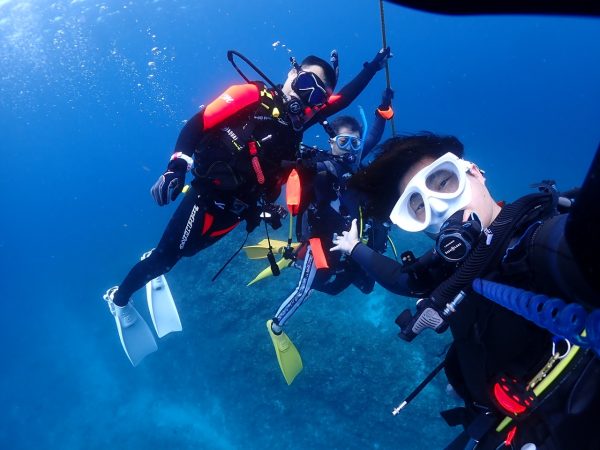 水中の集合写真を撮っているダイバー