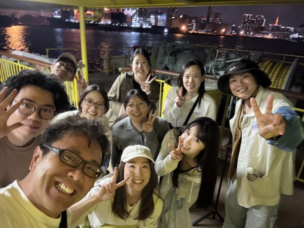 甲板の上複数の男女が集合写真